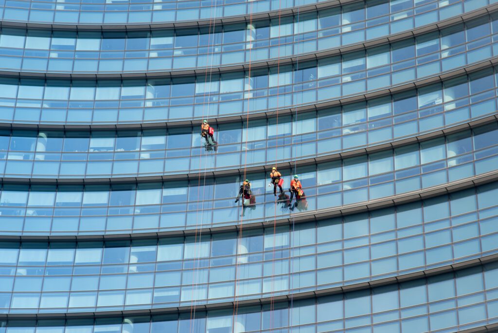 Window cleaners suspended on side of a skyscraper